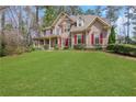 Inviting two-story home with red shutters, lush green lawn, and a classic front porch at 2320 Starr Lake Nw Dr, Acworth, GA 30101