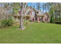 Beautiful two-story home featuring a lush green lawn, complemented by a charming front porch at 2320 Starr Lake Nw Dr, Acworth, GA 30101
