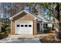 Charming single-story home featuring a one-car garage, a cozy front porch, nestled amid mature trees and landscaping at 309 Elizabeth Blvd, Alpharetta, GA 30009
