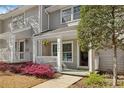 Attractive townhome with cozy front porch featuring swing and blooming landscaping at 2794 Farmstead Se Rd, Smyrna, GA 30080
