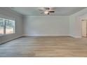 Open living room features wood-look flooring, large windows, crown molding, and a modern ceiling fan at 4574 Eastbrook Pl, Snellville, GA 30039