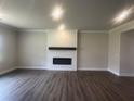A spacious living room featuring a fireplace, plank flooring, and bright lighting at 4574 Eastbrook Pl, Snellville, GA 30039