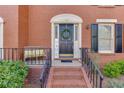 Charming entryway with brick stairs, decorative wreath, and cozy seating area at 102 Defoors Mill Dr, Atlanta, GA 30318