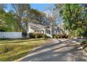 Quaint home showcasing a manicured lawn, mature trees, and a private driveway at 615 Collier Nw Rd, Atlanta, GA 30318