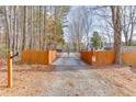 Gated driveway entrance providing added security to the property with a fenced perimeter and trees at 1195 Braselton Hwy, Lawrenceville, GA 30043