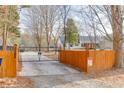 Long, gated driveway with wooden fence offering security and privacy to the home and property at 1195 Braselton Hwy, Lawrenceville, GA 30043