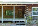 Close-up of the log cabin's front porch, showcasing the wooden door and stone accents at 1615 Hilltop Ct, Woodstock, GA 30188