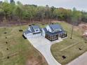 An aerial view of a luxury home with a long driveway and a spacious lawn in a wooded community at 3078 Turning Creek Trl, Dacula, GA 30019
