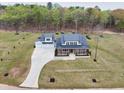 A birds-eye-view of a luxury home with a long driveway and a spacious lawn in a wooded community at 3078 Turning Creek Trl, Dacula, GA 30019