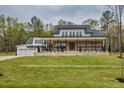 Beautifully designed two-story home featuring a brick-and-white facade, a covered porch, and three-car garage at 3078 Turning Creek Trl, Dacula, GA 30019