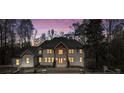 Charming light brick home with elegant design details and ample windows lit up against the night sky at 450 Birkdale Dr, Fayetteville, GA 30215