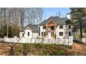 Beautiful home with a blooming flower garden, well-maintained lawn, and a light brick exterior at 450 Birkdale Dr, Fayetteville, GA 30215