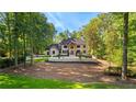 A two-story brick home sits on a well manicured lawn, with mature trees in the background at 450 Birkdale Dr, Fayetteville, GA 30215