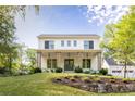 Charming two-story house with a stone retaining wall, white painted brick, and a welcoming front porch at 48 25Th St, Atlanta, GA 30309
