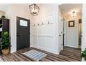 Welcoming entryway featuring modern light fixtures, stylish wood flooring, and convenient wall-mounted coat hooks at 6060 Carriage Dr, Cumming, GA 30028