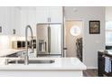 Modern kitchen featuring stainless steel appliances, white cabinetry, and a convenient laundry area at 6060 Carriage Dr, Cumming, GA 30028