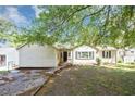 View of charming single-story home surrounded by mature trees offering shade and character at 2194 Ivydale St, Atlanta, GA 30344