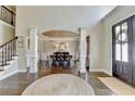Grand foyer with hardwood floors, elegant columns, staircase, and a view into the dining room at 6770 Ulster Ct, Alpharetta, GA 30005