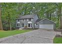 Inviting gray brick home nestled among mature trees with a long cracked driveway at 9415 Martin Rd, Roswell, GA 30076