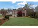 Beautiful two-story brick home with a well-manicured lawn and a three-car garage at 5450 Piney Grove Dr, Cumming, GA 30040