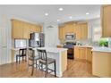Kitchen featuring wood cabinets, stainless steel appliances, and a center island with bar seating at 5450 Piney Grove Dr, Cumming, GA 30040