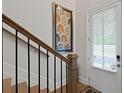 Light-filled foyer and staircase featuring hardwood floors, decorative art, and a window at 756 Stickley Oak Way, Woodstock, GA 30189