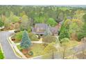 A beautiful two-story home surrounded by lush green trees and a well-manicured lawn at 800 Flathead Pass, Suwanee, GA 30024