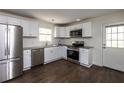 Well-lit kitchen boasts stainless steel appliances, granite countertops, subway tile backsplash, and hardwood flooring at 4704 Apache Sw Trl, Atlanta, GA 30331