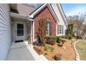 Inviting front entrance with landscaped garden, features a cozy outdoor space with shrubs and decorative elements at 1545 Heatherton Rd, Dacula, GA 30019