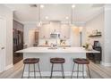 Modern kitchen with marble countertops, pendant lighting, stainless steel appliances, and three bar stools at 2240 Arnold Mill Nw Rd, Lawrenceville, GA 30044