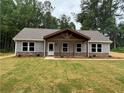 A charming home featuring a cozy covered porch and a beautifully landscaped front yard at 482 West Ave, Bowdon, GA 30108
