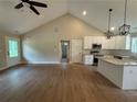 Open concept living space with vaulted ceiling, hardwood floors, and adjacent kitchen at 482 West Ave, Bowdon, GA 30108