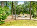 Inviting single-story home with stone accents and a two-car garage surrounded by lush greenery and mature trees at 247 Old Timber Rd, Lawrenceville, GA 30046