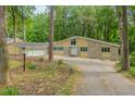 Charming single-story home with stone accents, multiple windows, and a spacious driveway nestled among mature trees at 247 Old Timber Rd, Lawrenceville, GA 30046