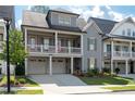 Attractive two-story home showcasing a welcoming front porch, attached garages, and lush landscaping at 319 Riverton Way, Woodstock, GA 30188