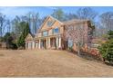 Brick home with large lawn, mature trees, blooming landscaping, and side-entry garage at 4710 Mcintosh Dr, Cumming, GA 30040