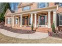 Inviting front porch with brick columns, manicured landscaping, and colorful flowers at 4710 Mcintosh Dr, Cumming, GA 30040