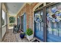 Inviting front porch with rocking chairs, blue door with floral wreath, and brick flooring at 2510 Bent Creek Way, Cumming, GA 30041