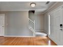 Inviting foyer with gleaming hardwood floors, staircase with carpet runner and stylish door at 3285 Watson Gate Rd, Loganville, GA 30052