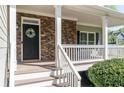 Inviting front porch featuring stone accents, white railing, and a decorative wreath at 55 Maple Leaf Ct, Dallas, GA 30157