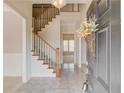 Welcoming foyer features a staircase with wood railings, tiled floor, and neutral paint at 5808 Deer Crossing Dr, Sugar Hill, GA 30518