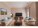 Cozy living room with neutral tones, plush seating, and large windows for ample light at 5808 Deer Crossing Dr, Sugar Hill, GA 30518