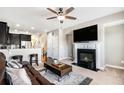 Cozy living room with a fireplace, ceiling fan, and open layout to the kitchen and staircase at 7620 Stoneridge Dr, Atlanta, GA 30328