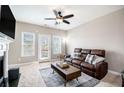 Comfortable living room with a fireplace, ceiling fan, and a large sofa, perfect for relaxation at 7620 Stoneridge Dr, Atlanta, GA 30328