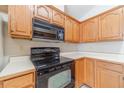 Classic kitchen with wooden cabinets and modern black appliances including oven range and microwave at 3005 Summit View Ct, Snellville, GA 30078