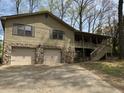 Home with two-car garage and stone accents, featuring a covered porch and wood siding at 302 Chattahoochee Way, Woodstock, GA 30188