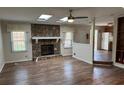 Living room with a stone fireplace, skylights, and wood floors, seamlessly connecting to the kitchen at 302 Chattahoochee Way, Woodstock, GA 30188