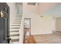 Bright foyer with tiled entry and hardwood steps offers a glimpse into the updated kitchen at 714 Post Road Dr, Stone Mountain, GA 30088