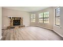 Spacious living room with stone fireplace, large windows and new light-grey laminate flooring at 714 Post Road Dr, Stone Mountain, GA 30088
