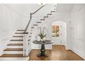 Elegant foyer with hardwood floors, staircase, wainscoting, and arched doorway at 235 The Prado N, Atlanta, GA 30309